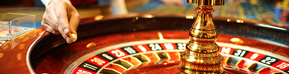 a croupier about to throw a ball on a roulette wheel