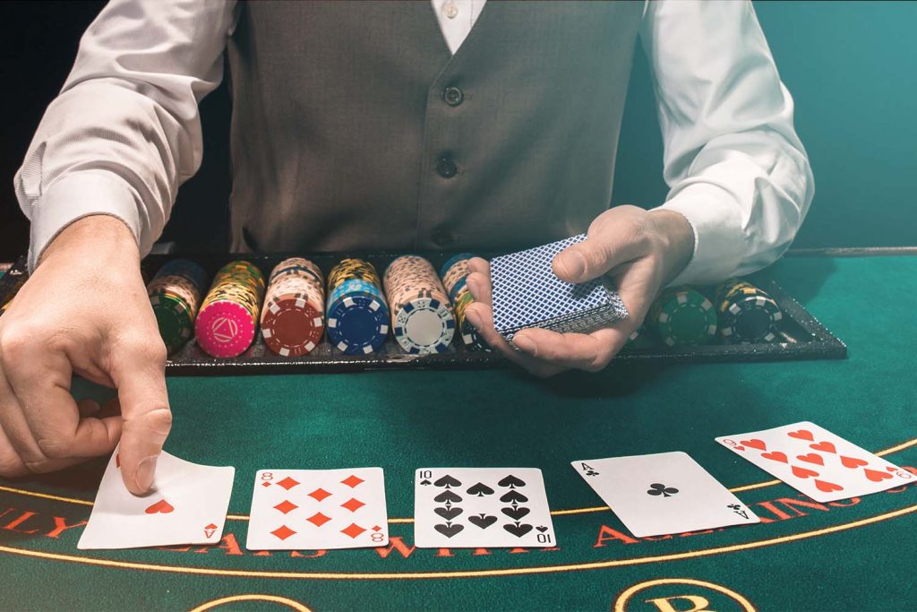 a dealer dealing cards on a blackjack table in front of him